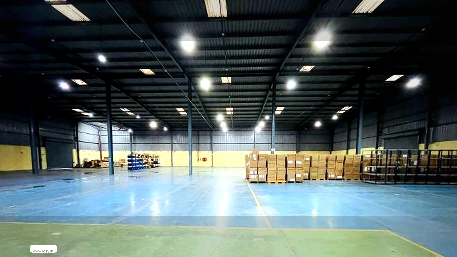 Storage hall at a Lozy warehouse in Garhi Harsaru, Gurugram, with palletised cartons, blue epoxy floor and selective pallet racking