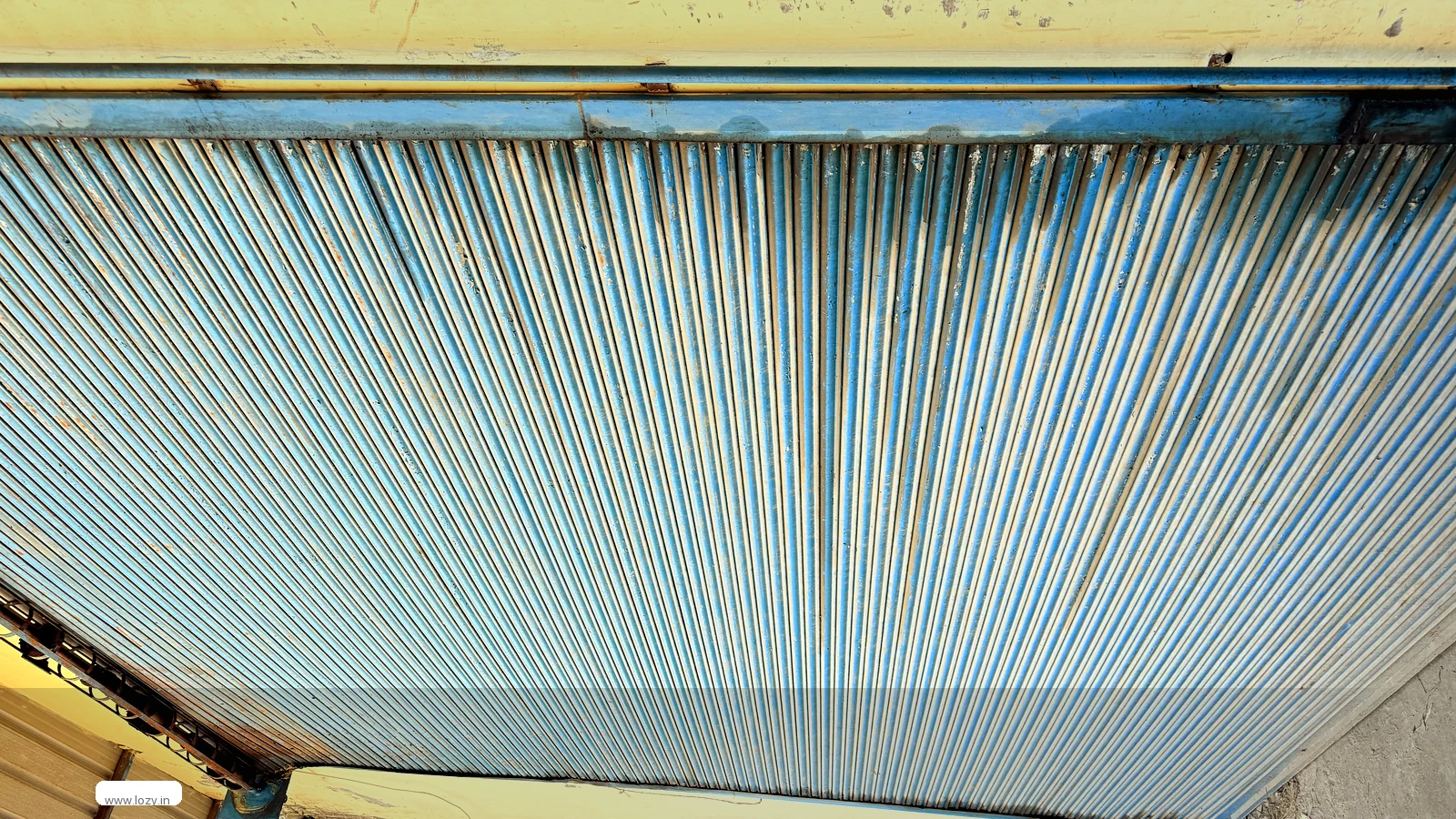 Corrugated metal cladding and a lower blue roof section on the Lozy warehouse building at Ghevra Metro 2, Delhi