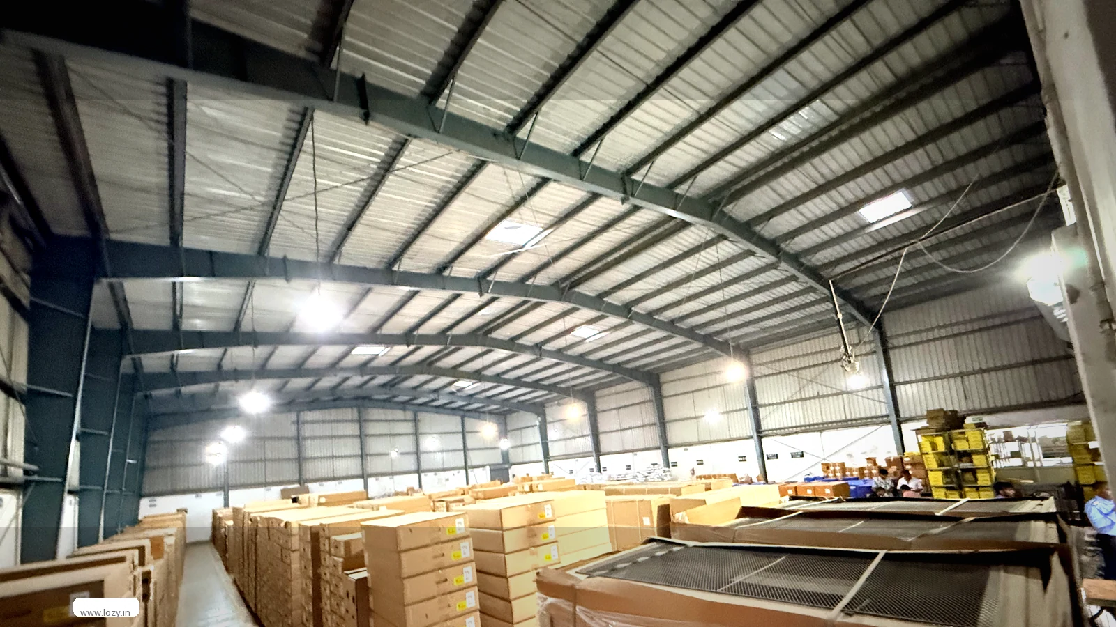 Lozy shared warehouse floor at Dwarka, Delhi - a clean concrete slab under clear-span roof trusses, an empty working bay a business can fill with pallets or a pick line
