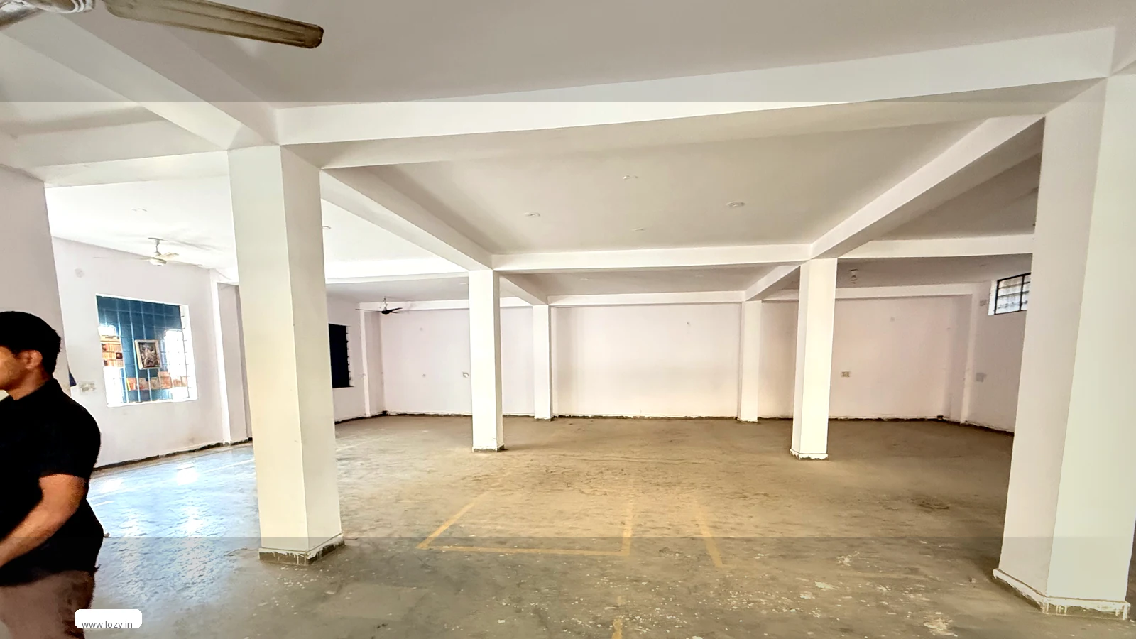Empty Lozy warehouse bay at Dwarka with blue columns and white aisle markings on a bare concrete floor, ready for a returns intake