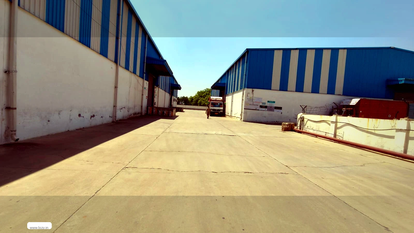 Lozy warehouse interior in Chennai with aisle markings, a steel racking run and a client's pallets staged on the concrete floor