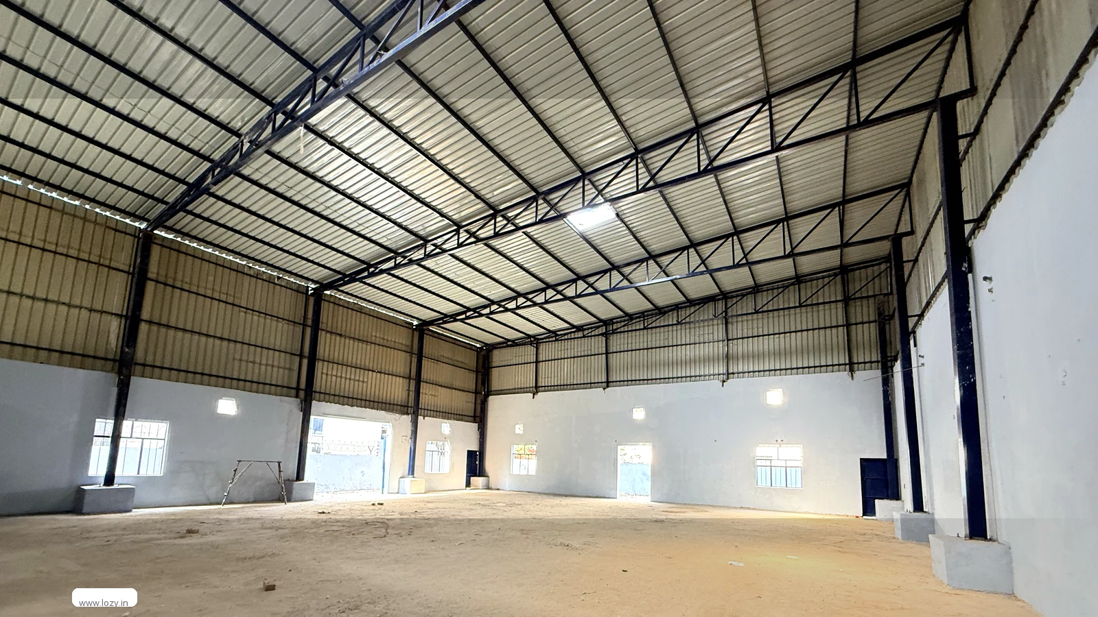 Lozy warehouse shed at Mansar 5 in the Manesar belt, Gurugram, with blue corrugated roof and gated paved approach