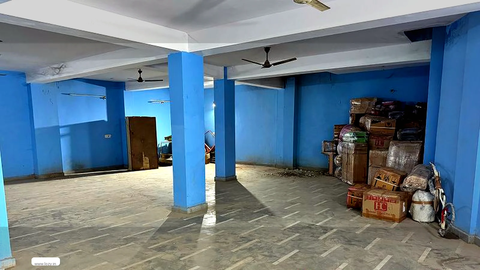 Empty industrial floor with columns, a roller shutter and polished concrete inside a DLF industrial estate building in Faridabad