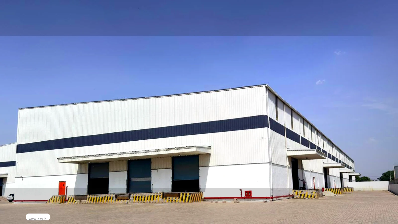 A distribution centre in Lozy's network: a wide loading apron, marked bays and stacked palletised stock under a high roof